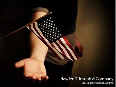 Person holding a small American flag. Hayden T Joseph & Company, Cross Border Tax Consultants.