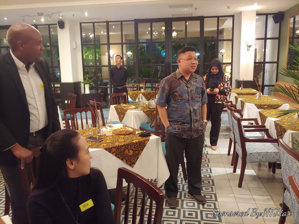 People gathered in a restaurant with tables set for dining.