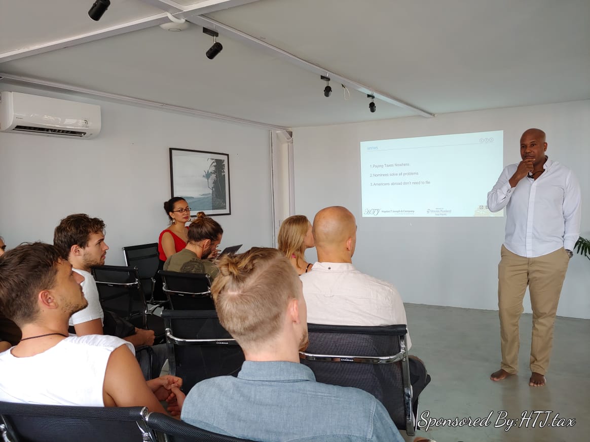 Man presenting myths about taxes to an audience. Screen shows "MYTHS" and three bullet points.
