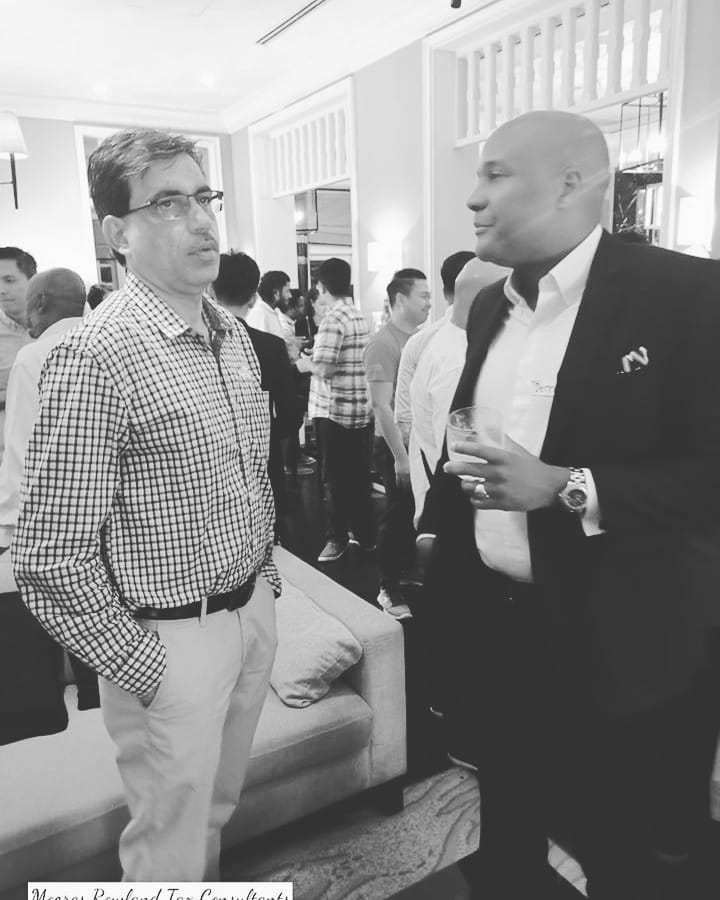 Two men in suits talking at a networking event.