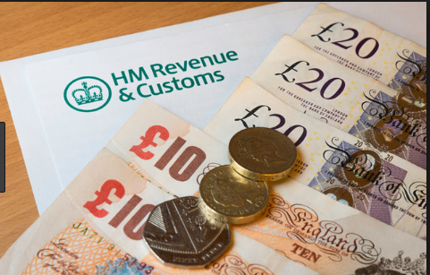 HM Revenue & Customs envelope with UK pound notes and coins.