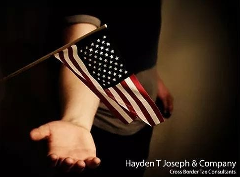 Hand holding a small American flag, with company name and tagline below.