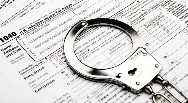 Handcuffs resting on a U.S. Individual Income Tax Return form 1040.