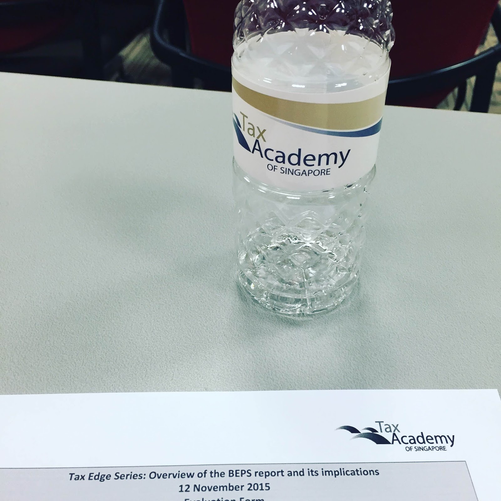 Bottle of water with Tax Academy of Singapore logo and document titled Tax Edge Series.