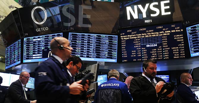 Traders on the floor of the NYSE with stock tickers displayed on screens.