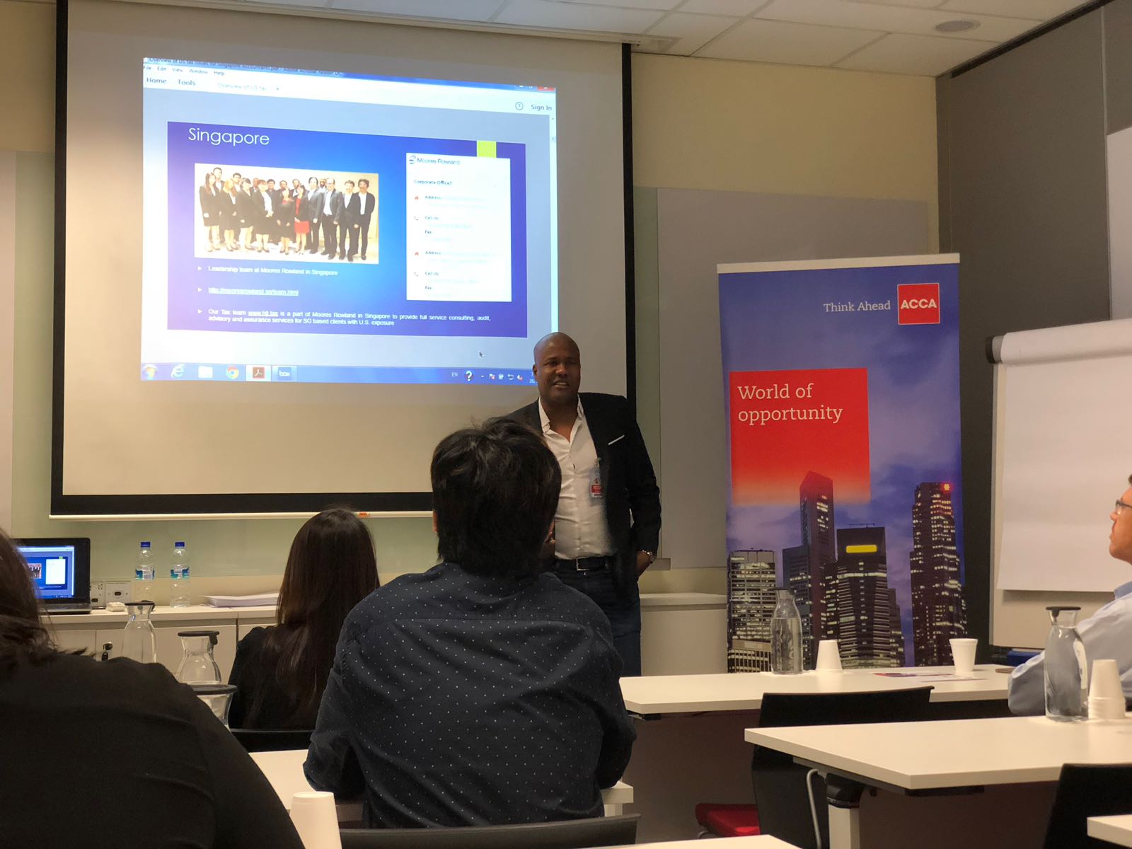 Presentation slide about Singapore and Moores Rowland, with speaker and ACCA banner.