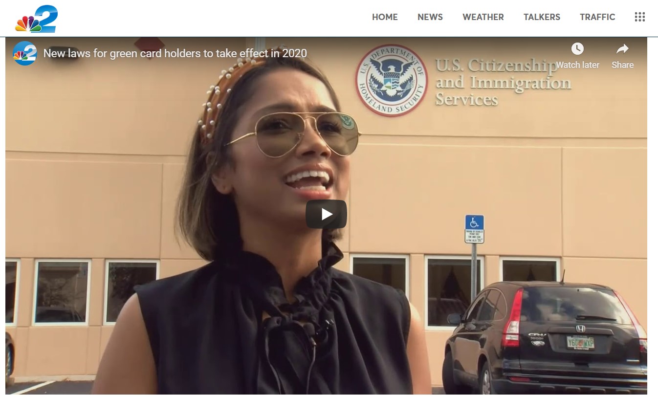 Woman in sunglasses in front of U.S. Citizenship and Immigration Services building.