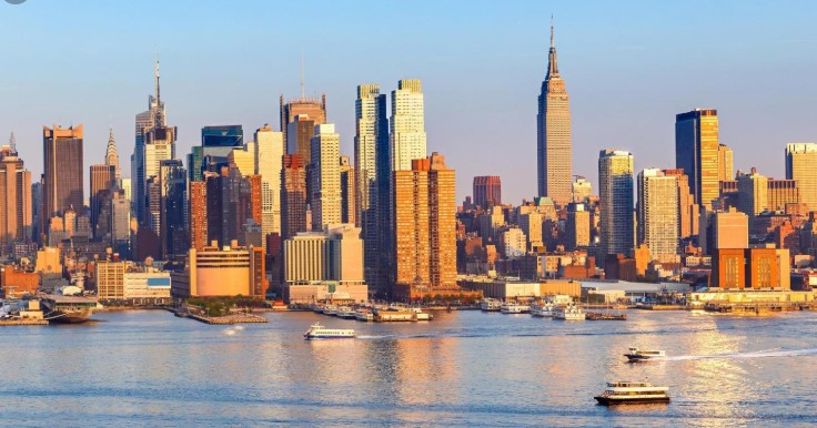 New York City skyline with Empire State Building and boats on the water.