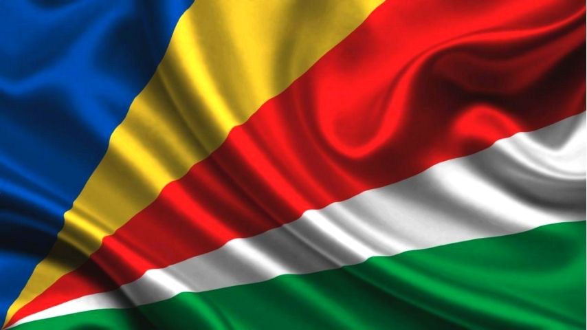 The flag of Seychelles with diagonal bands of blue, yellow, red, white, and green.