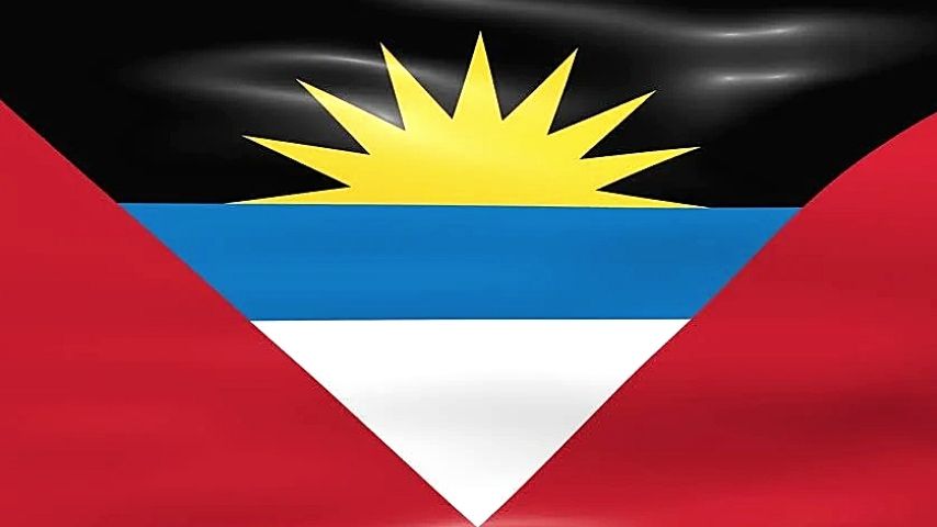 Flag of Antigua and Barbuda with a yellow sun rising over blue and white stripes, bordered by red.